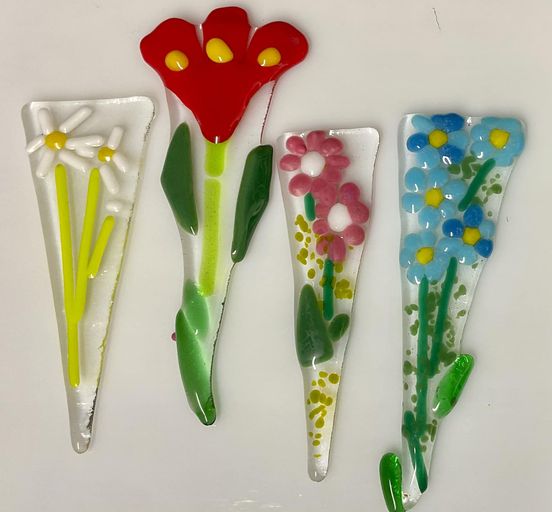 Image of triangular fused glass with representations of spring flowers.
